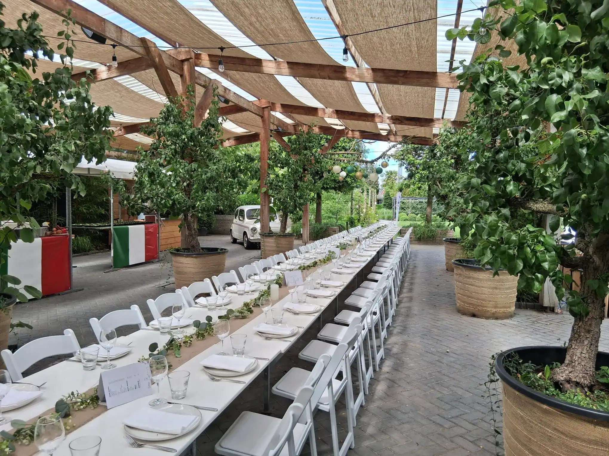 Lange tafel onder de overkapping in de tuin