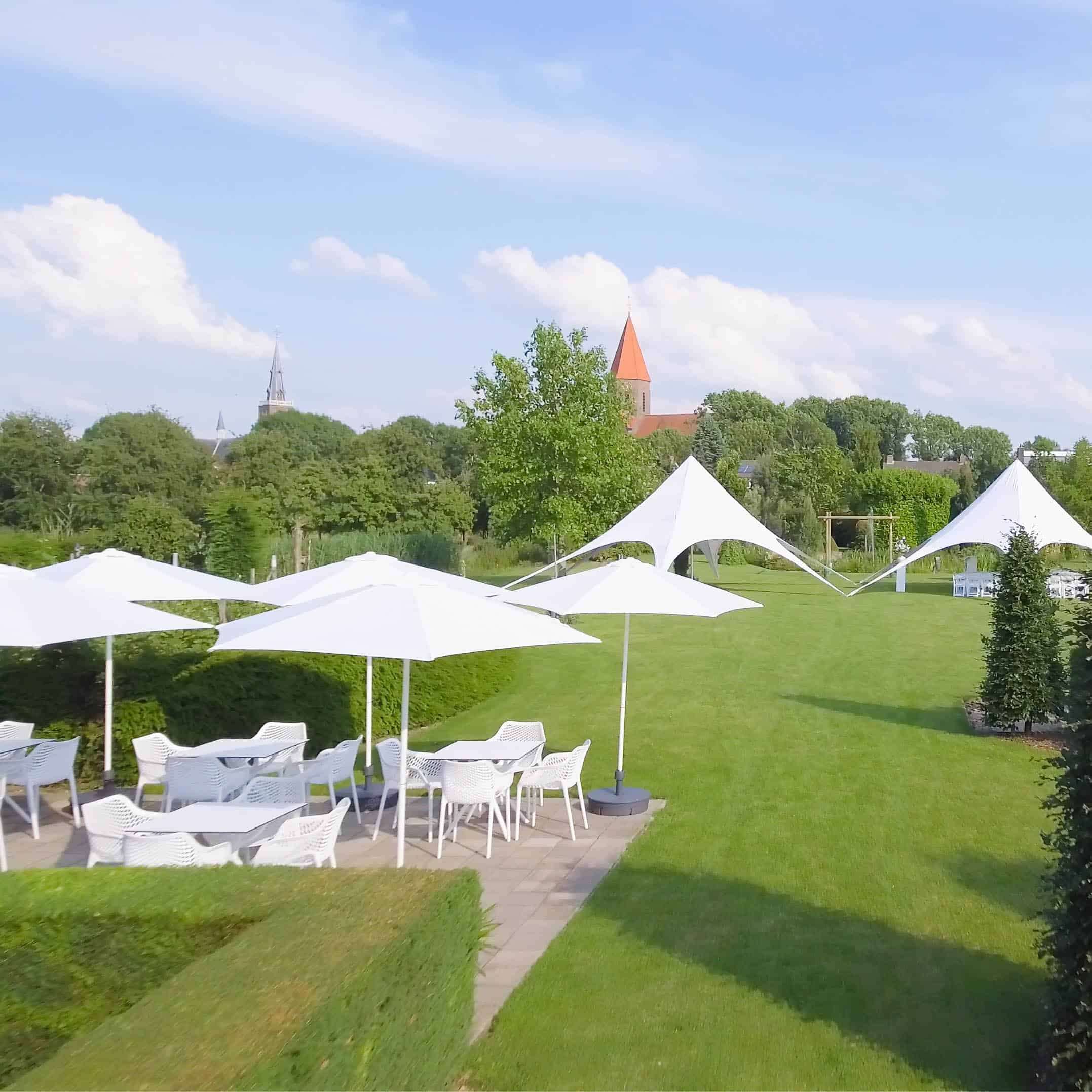 Luchtfoto van Tuin de Hoge Waard met tenten en parasols op het gras