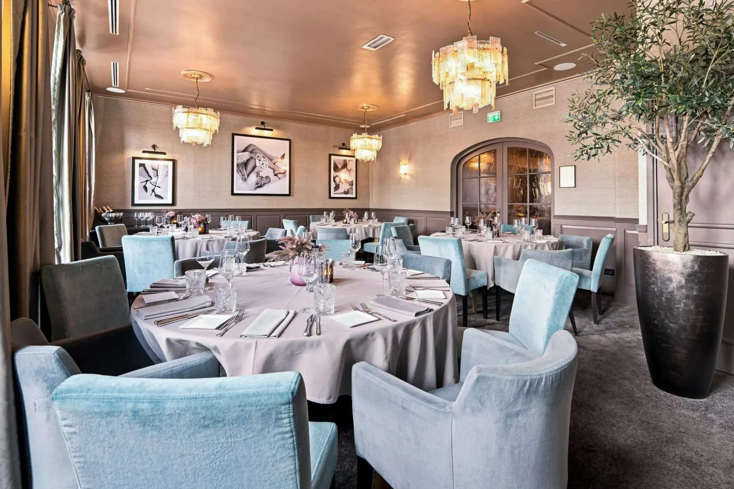 IJsselzaal met ronde tafels, lichtblauwe fauteuils en kroonluchters