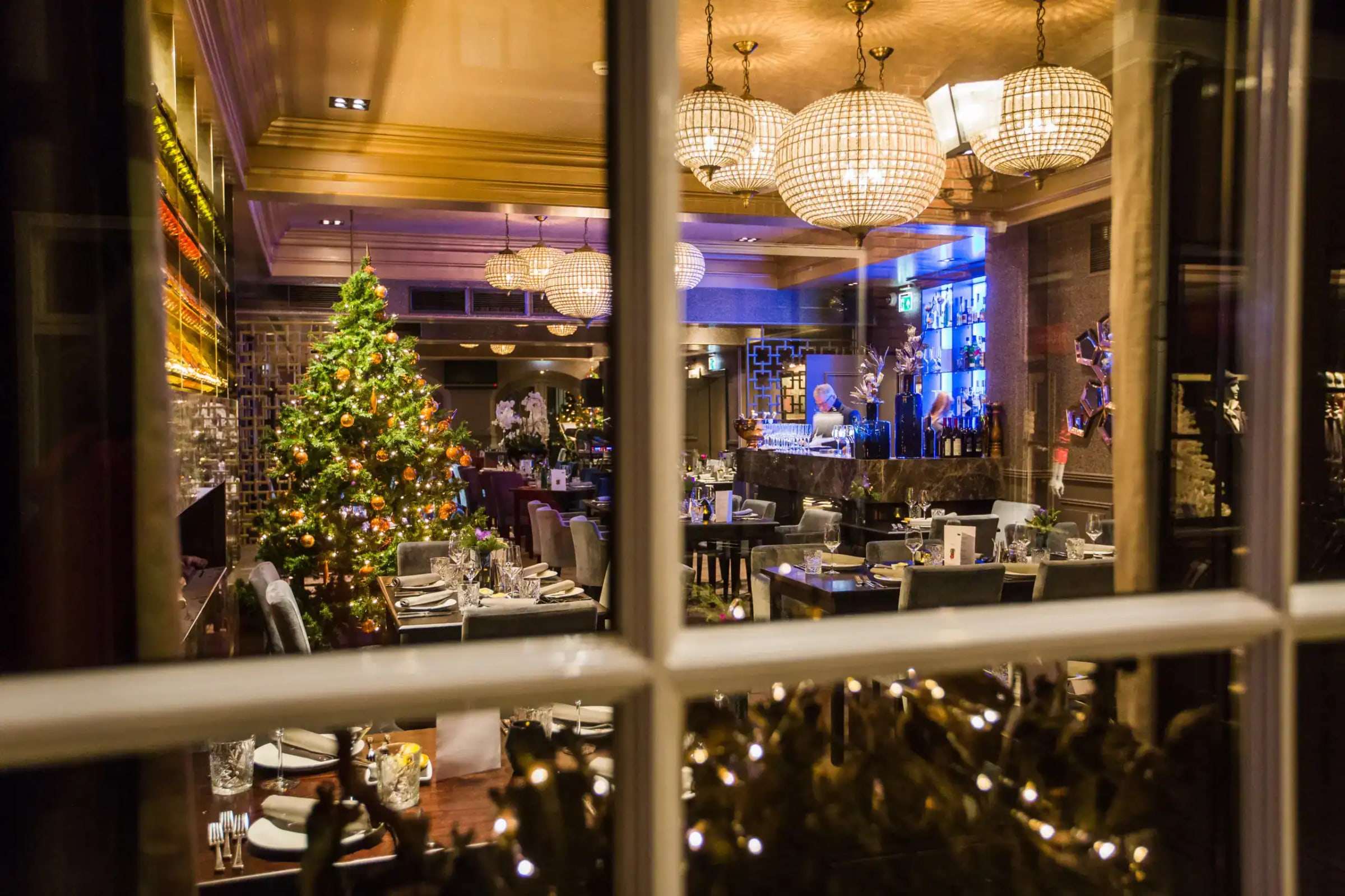 Doorkijk door het raam naar het restaurant in kerstsfeer