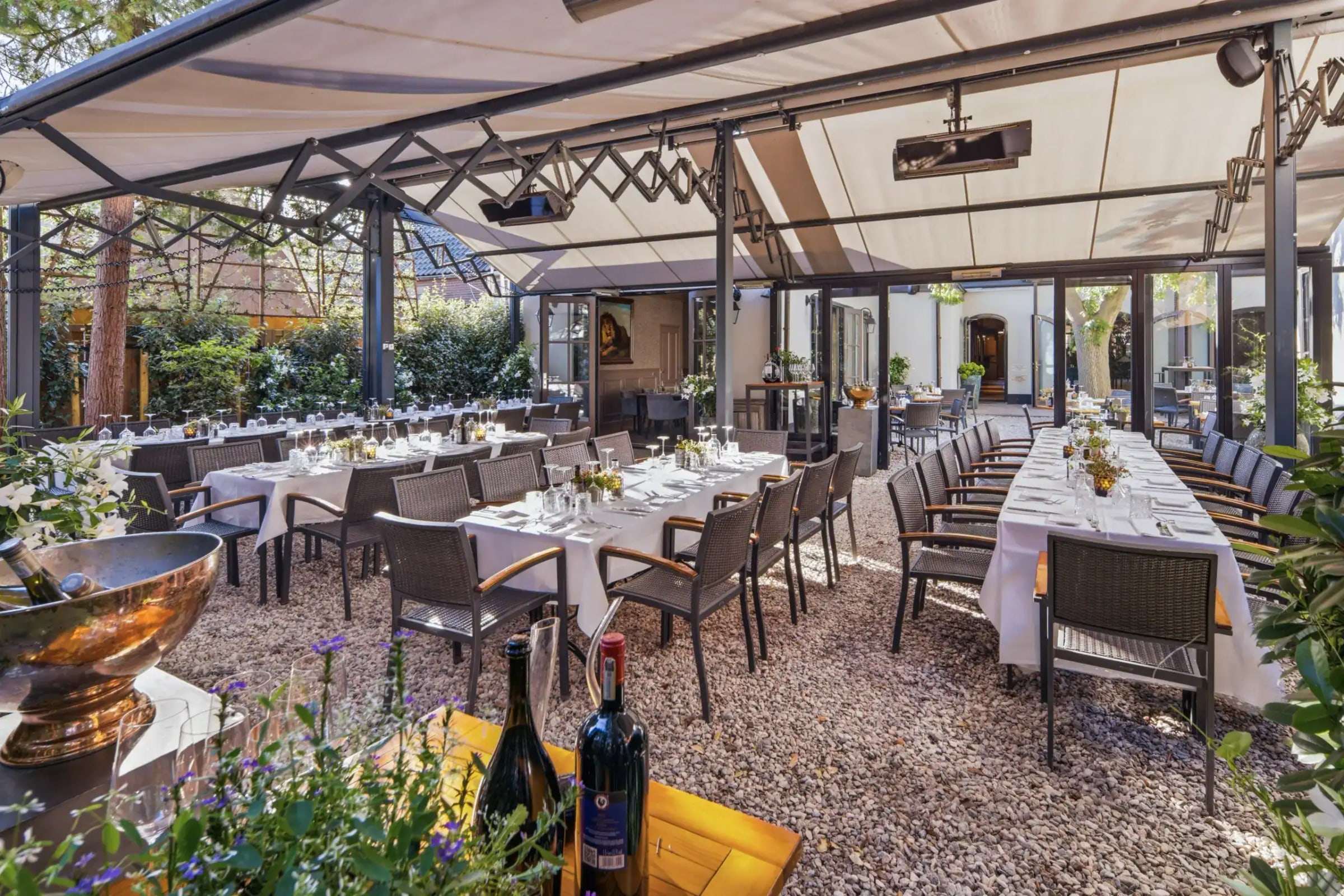 Lange gedekte tafels onder de overkapping van het Heerenterras