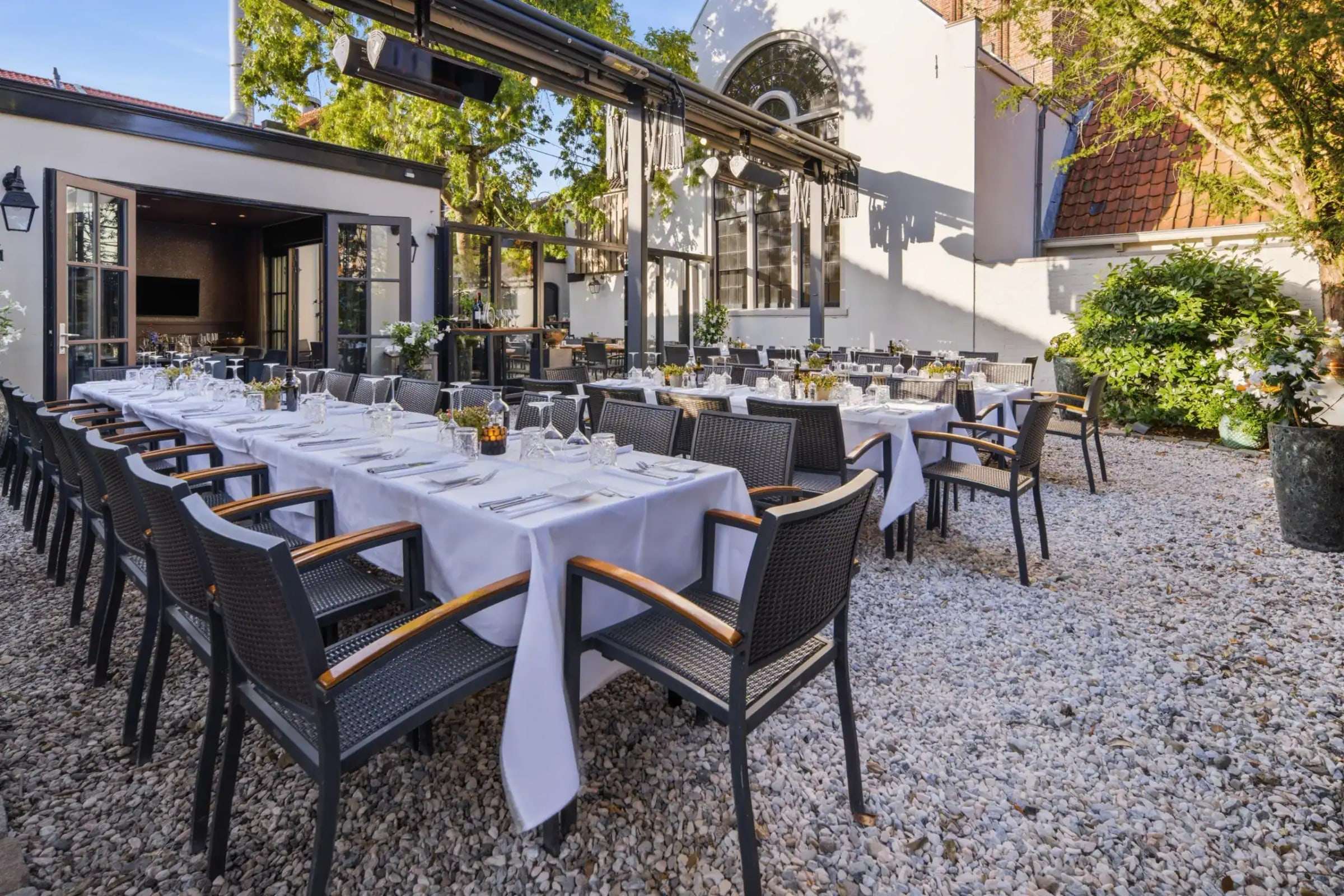 Overkapt Heerenterras met lange gedekte tafels en heaters