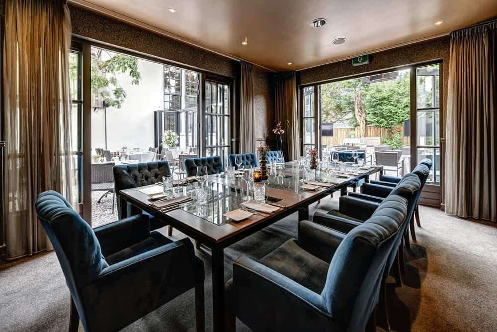 Terraszaal met lange tafel en openslaande deuren
